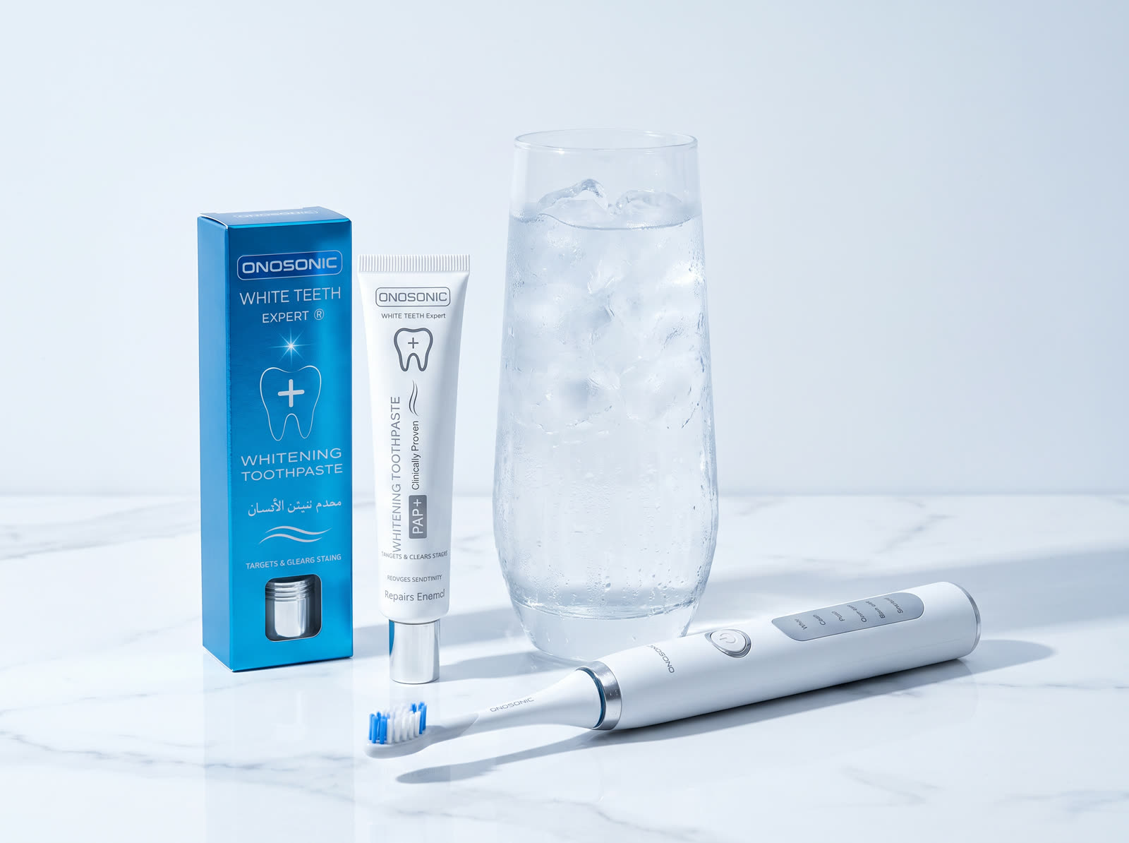 A glass of iced water beside ONOSONIC whitening toothpaste and the DX-1 toothbrush